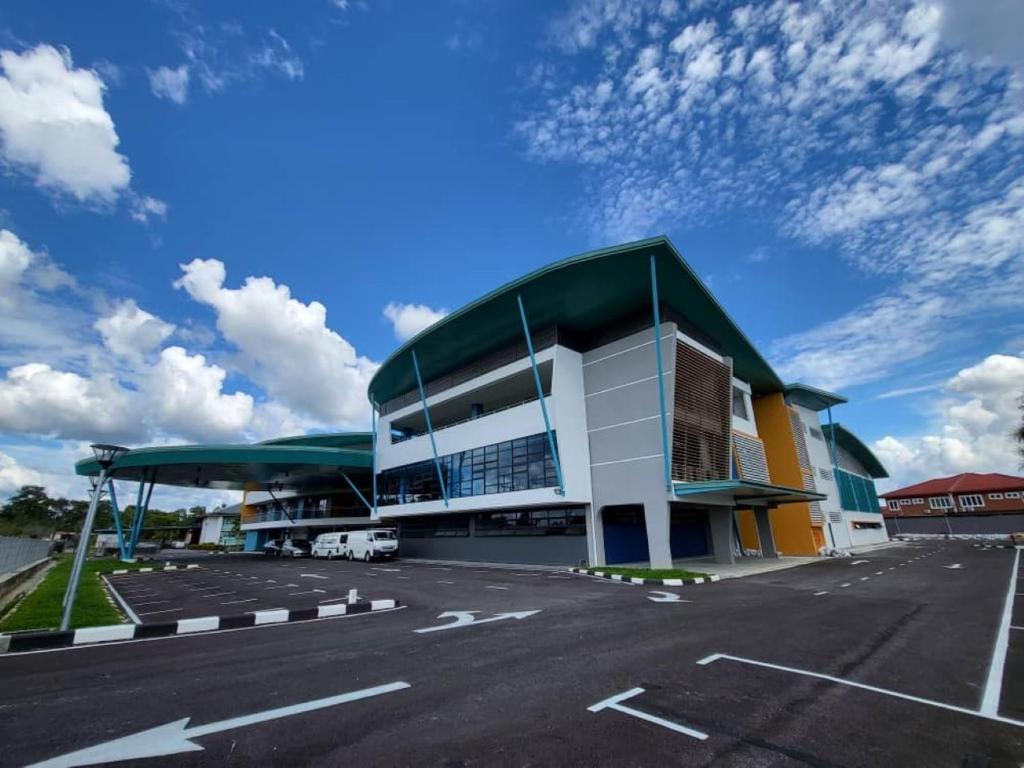 um parque de estacionamento em frente a um grande edifício em Agape Hostel em Sibu