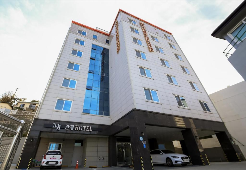 a hotel with cars parked in front of it at Mj Hotel in Yeosu