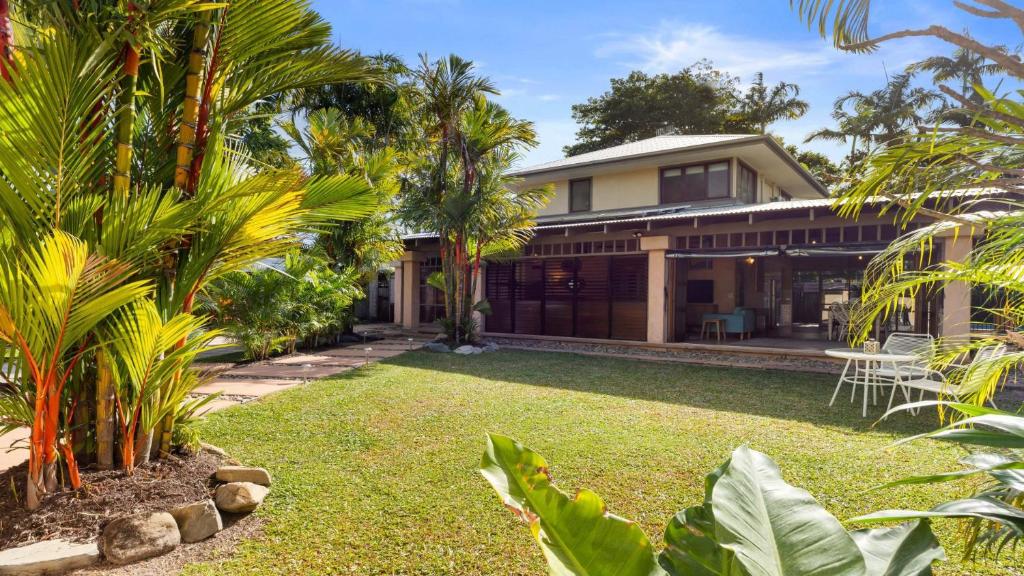 una casa con un patio con palmeras en Privacy On Pecten Port Douglas, en Port Douglas