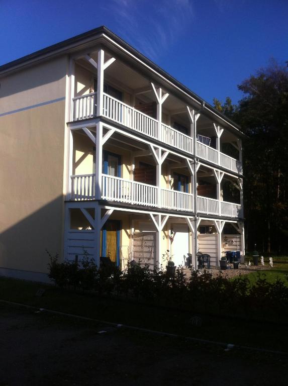 a white building with a balcony on the side of it at Ostseeerlebnis in Graal-Müritz