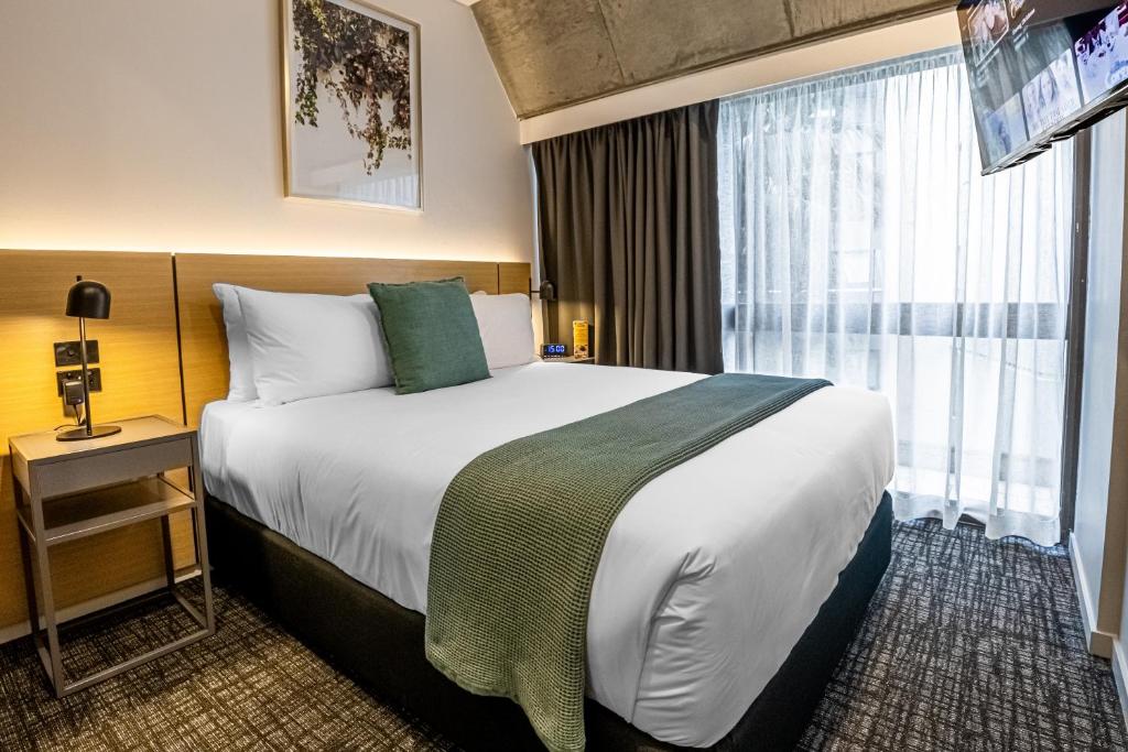 a hotel room with a large bed and a window at Song Hotel Sydney in Sydney