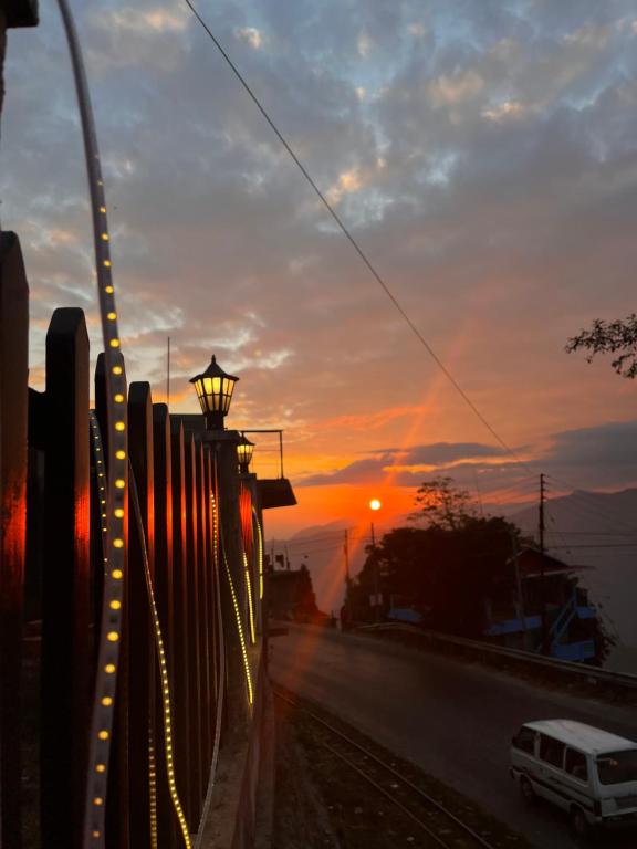 a van driving down a street at sunset at EJ’s Frontyard- The Home Cafe & Stay in Kurseong