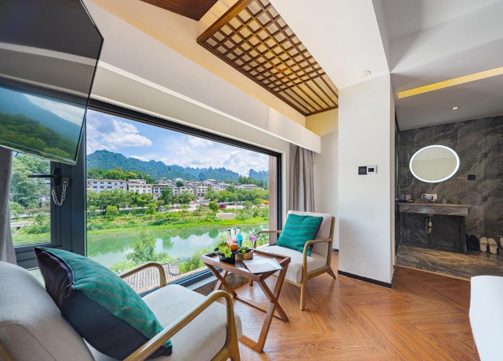 张家界Riverside Peak Lodge Zhangjiajie Wulingyuan National Park的客厅设有美景大窗户
