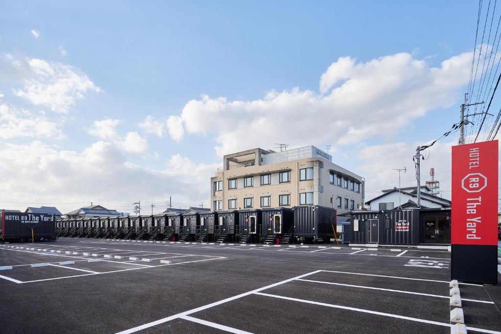 長浜市にあるHOTEL R9 The Yard Nagahamaの白い建物の駐車場