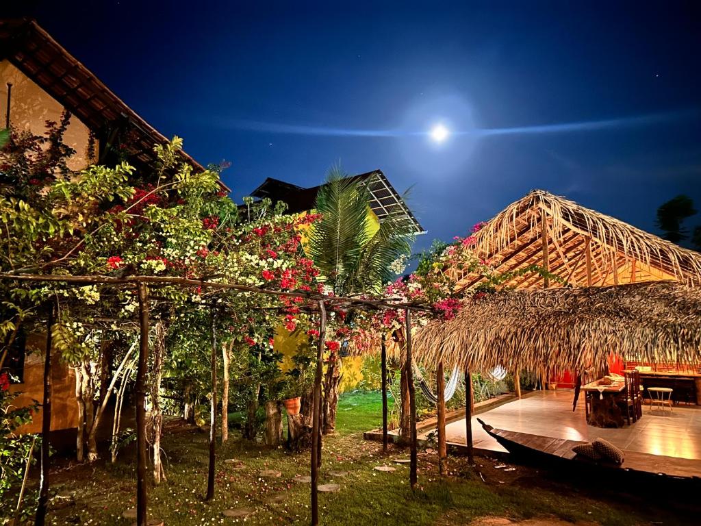 een resort met een bos bloemen en een gebouw bij Vila Ypáwa 150 m centro 30 m praia lago verde in Alter do Chao