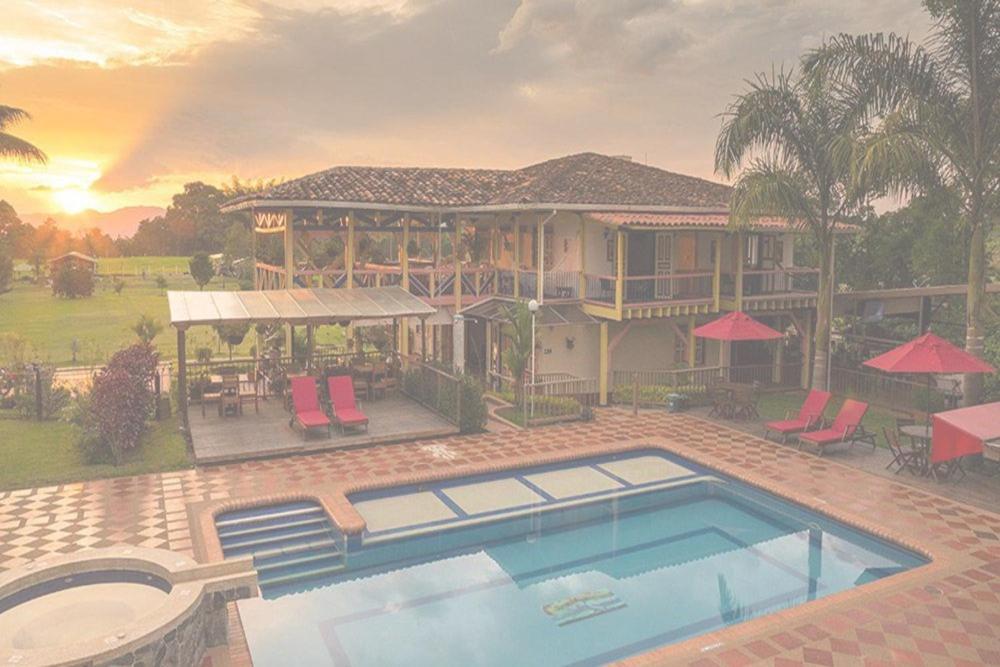 una casa grande con piscina frente a ella en Biohotel serenity spa, en Quimbaya