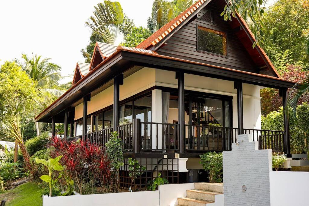 a house with a porch and a balcony at Baan Chom Chan in Koh Phangan