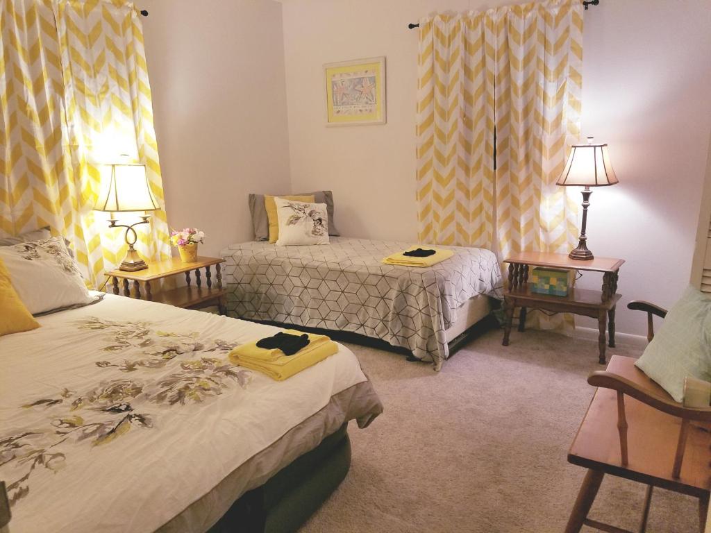a bedroom with two beds and two tables with lamps at Getaway in a Spacious Pool Home in Tampa