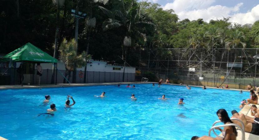 un gruppo di persone in piscina di Acogedor Apartaestudio Tricentenario Medellín a Medellín