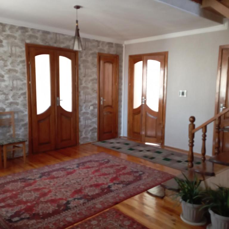 uma sala de estar com duas portas e um tapete em Канышай em Osh