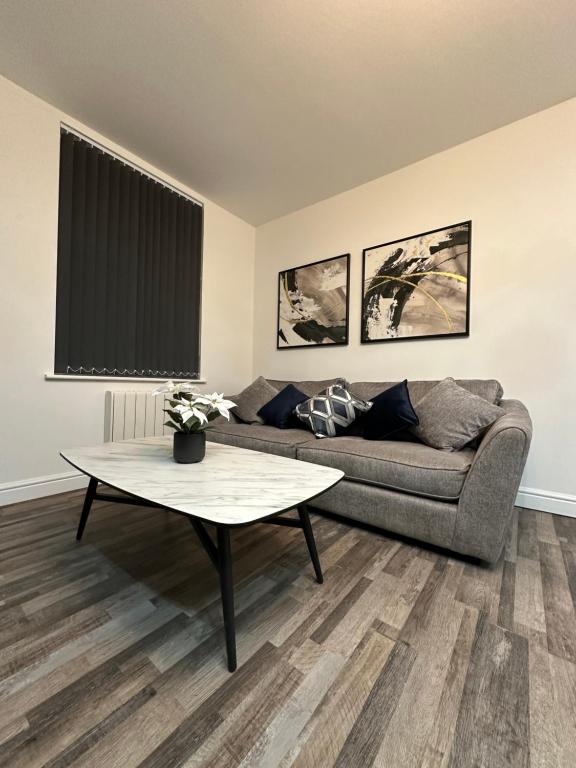 a living room with a couch and a table at Stylish Leeds City Apartment in Headingley