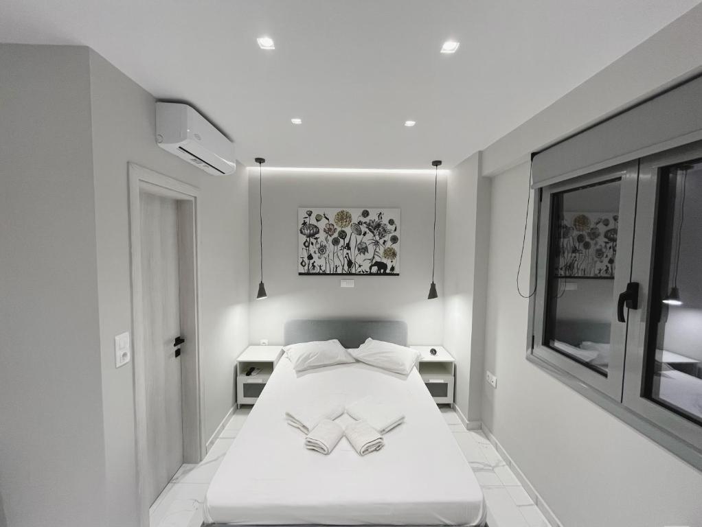 a bedroom with a white bed with two books on it at BlueLine apartment 2 in Loutraki