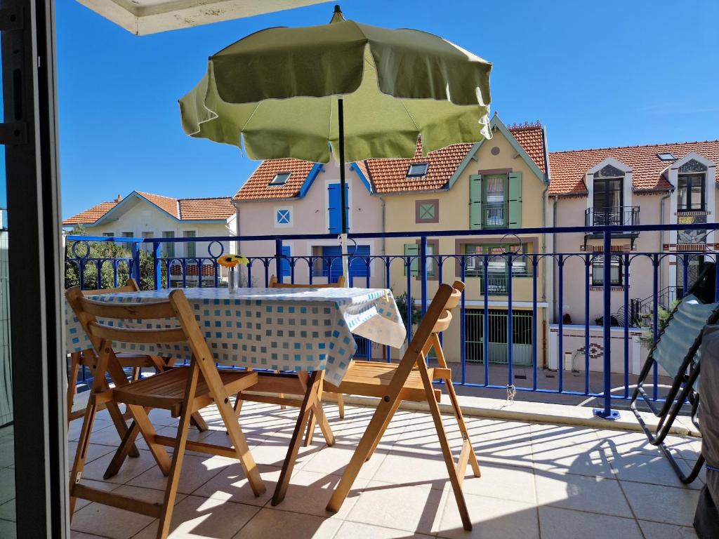 a table and chairs with an umbrella on a balcony at Appartement Châtelaillon-Plage, 2 pièces, 4 personnes - FR-1-706-12 in Châtelaillon-Plage