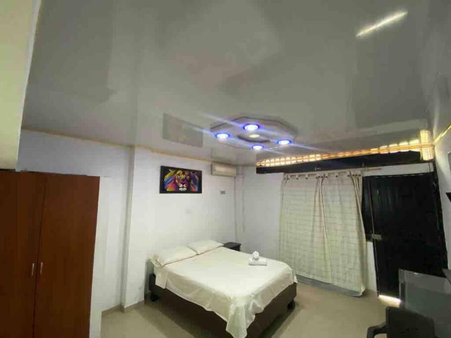 a bedroom with a bed in a room with a ceiling at Apartaestudio privado con aire cerca Aeropuerto in Cali