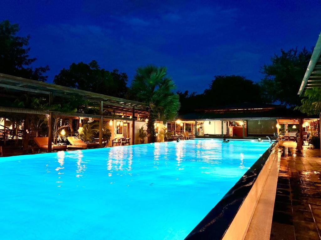 a large swimming pool at night at Peam Snea Resort in Kampot