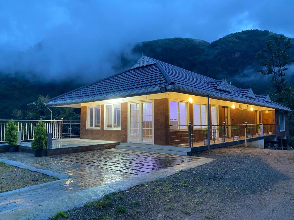 una pequeña casa con porche por la noche en Earth Lounge Resort en Vagamon