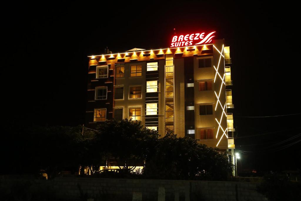 a building with a sign on top of it at night at Breeze Suites in Devanahalli-Bangalore