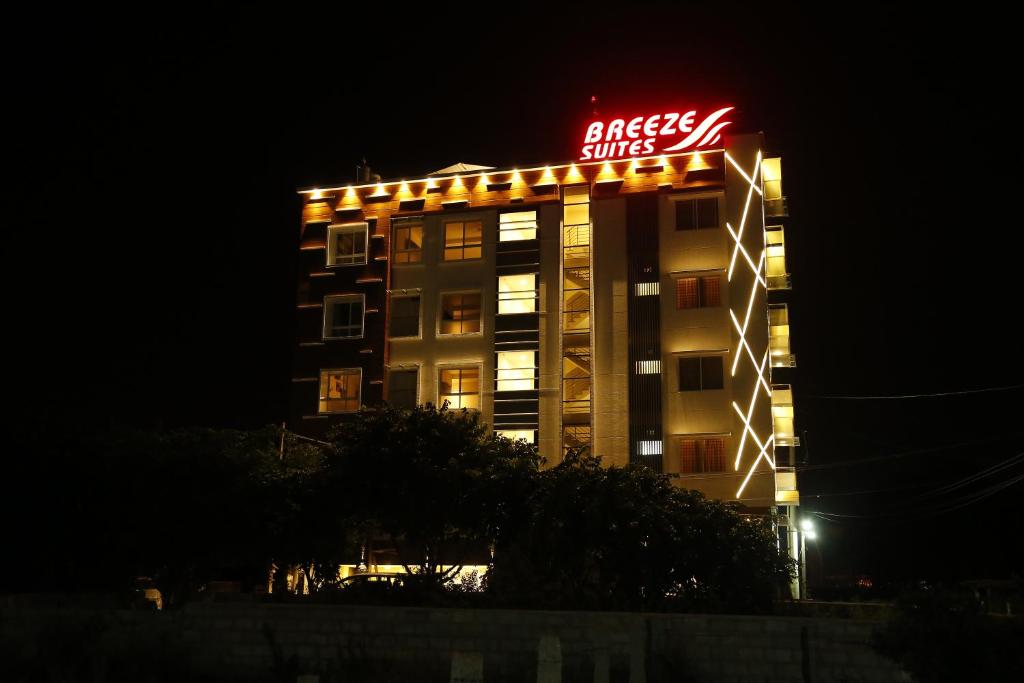 a building with a sign on top of it at night at Breeze Suites in Devanhalli