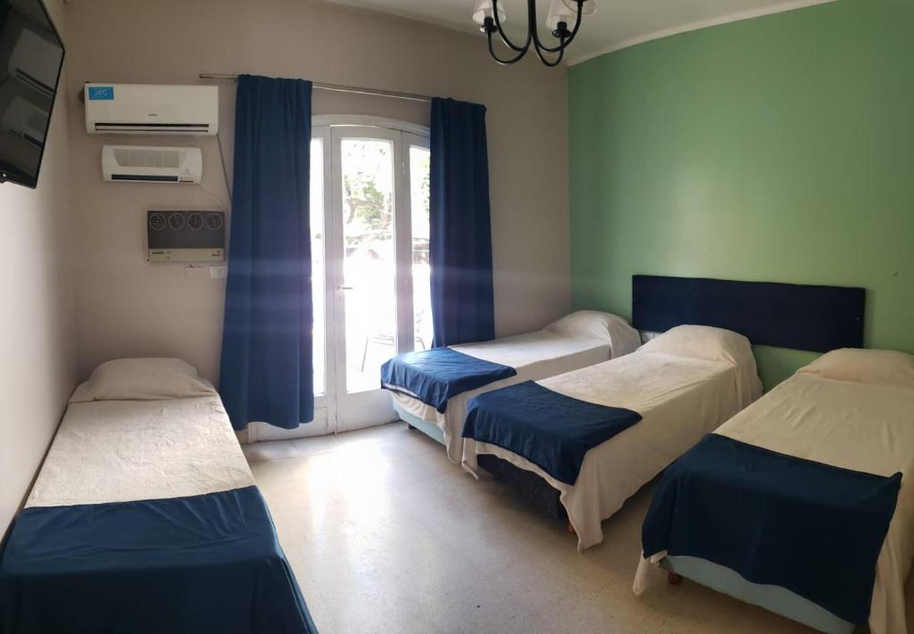 una camera ospedaliera con tre letti e una finestra di Hotel Namaste a Mendoza