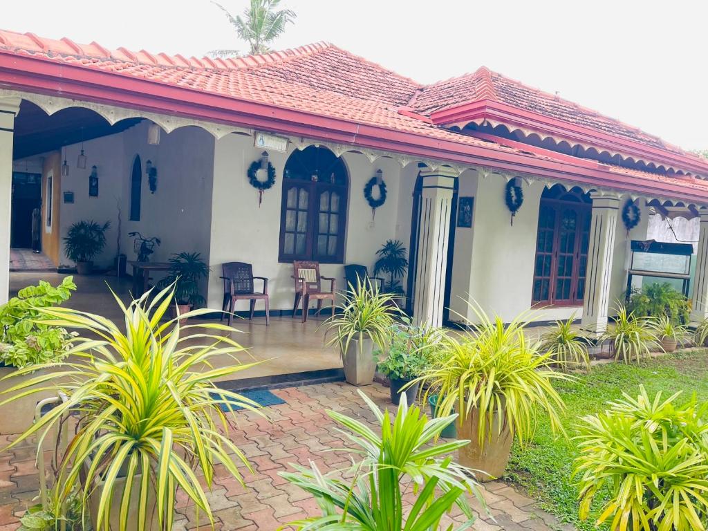 a white house with plants in front of it at Shalomi's villa & Happy Home in Negombo