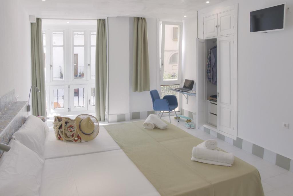 タリファにあるHostal Gravinaの白いソファと青い椅子が備わる白い部屋