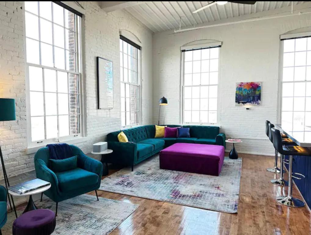 ein Wohnzimmer mit grüner Couch und lila Möbeln in der Unterkunft Penthouse: Casa Colore in Utica