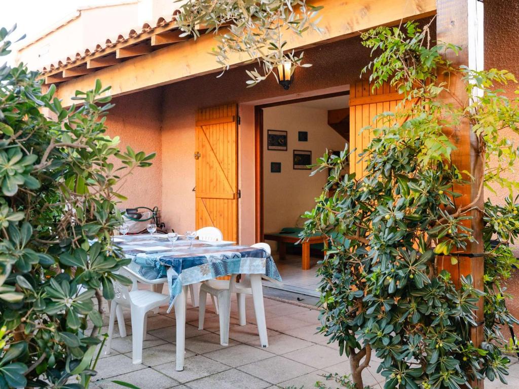 une table et des chaises sur le patio d'une maison dans l'établissement Gruissan : Pavillon 3 pièces, 6 pers, piscine privée, près plage et centre – animaux acceptés - FR-1-409-246, à Gruissan