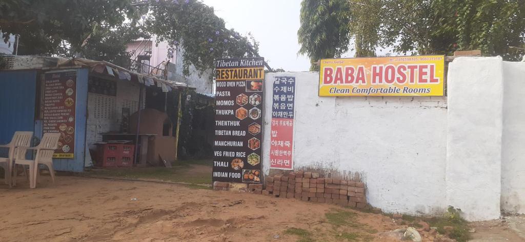 un panneau indiquant un restaurant bajaoked à côté d'un mur dans l'établissement Baba hostel, à Pushkar