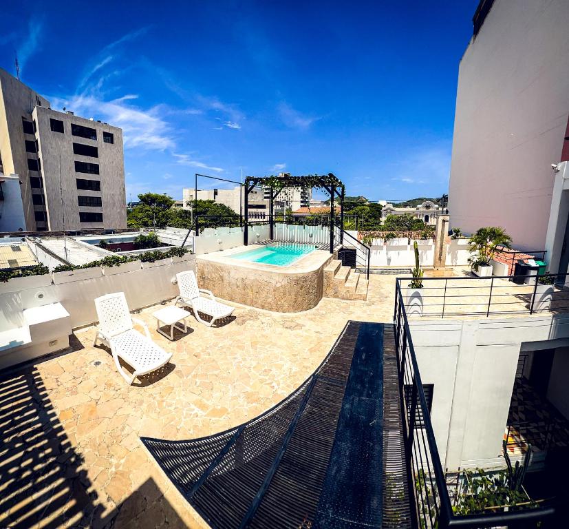a patio with chairs and a swimming pool on a building at The Orange House Santa Marta in Santa Marta