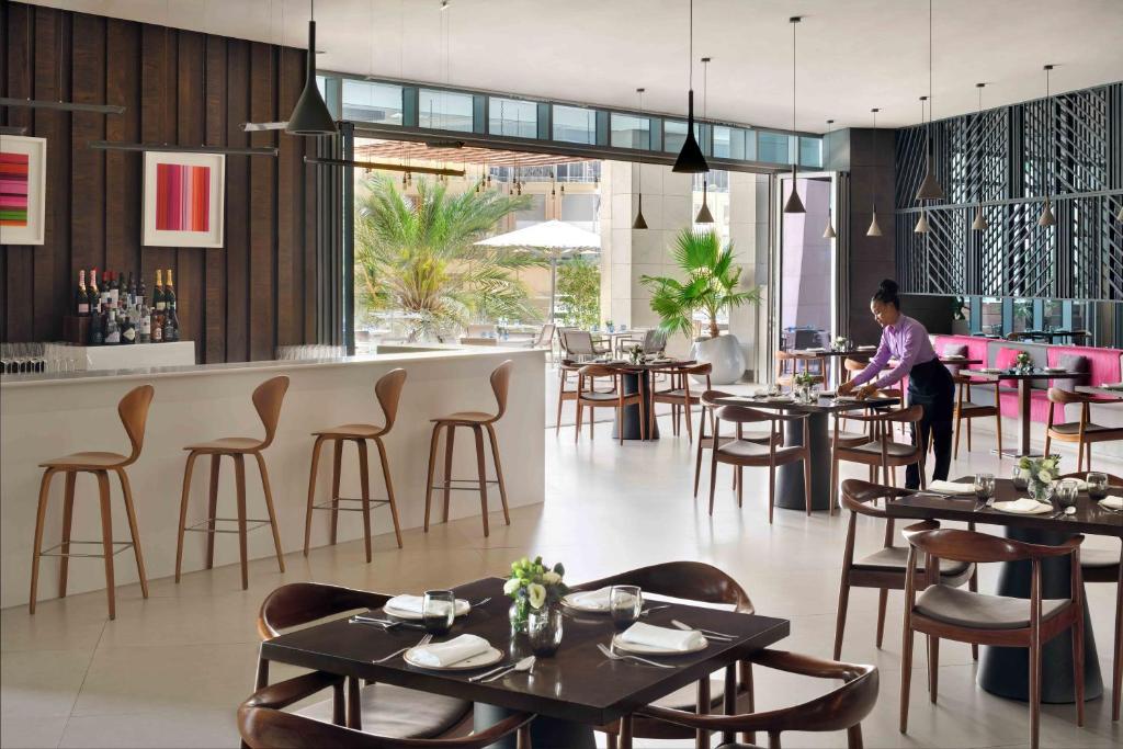 a woman sitting at a table in a restaurant at InterContinental Dubai Marina by IHG in Dubai
