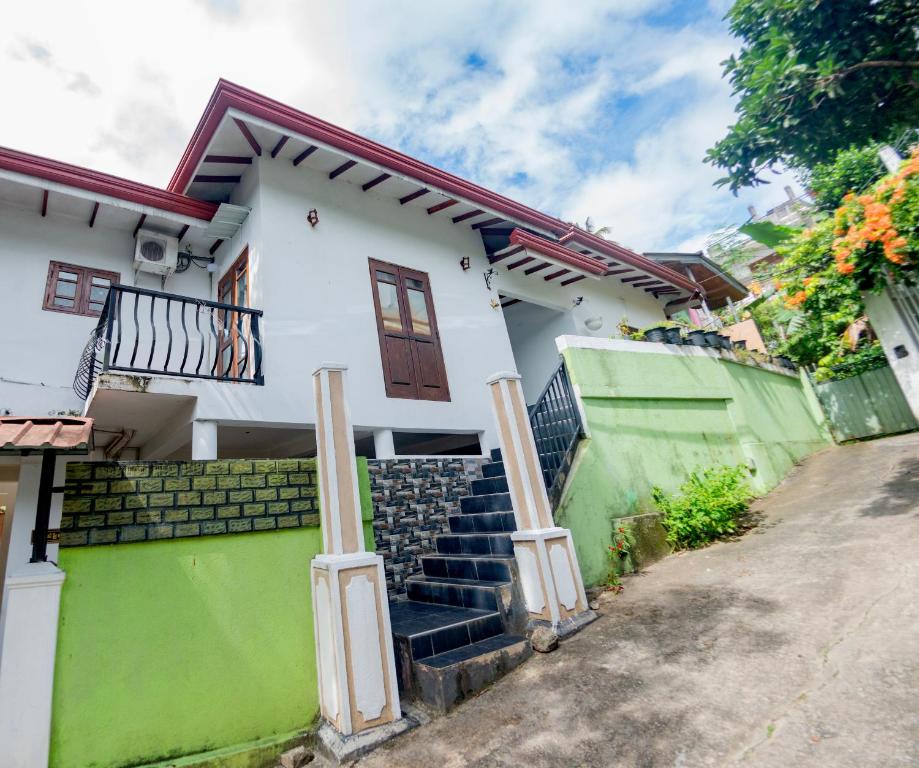 a white house with stairs in front of it at Ciel Grand Villa in Kandy