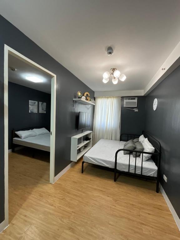 a bedroom with two beds and a mirror at Condo Rentals in Arezzo - 1 Br Condo in Davao City