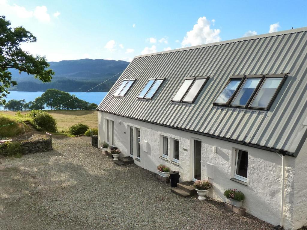 a white house with a view of the water at The Stable in Dalavich