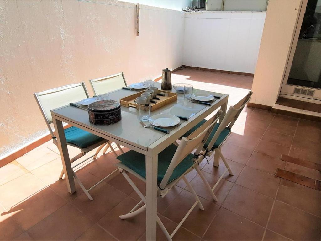 - une table avec des chaises et une bouteille de vin dans l'établissement Apartamento Llançà, 3 dormitorios, 6 personas - ES-170-84, à Llançà