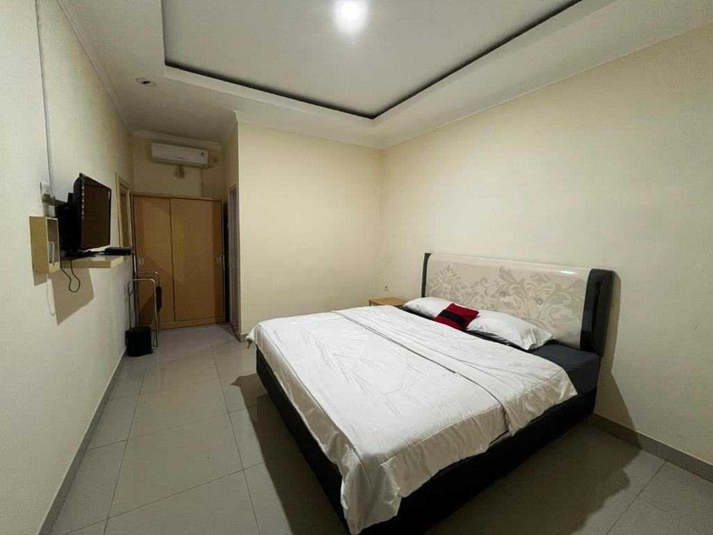 a bedroom with a large bed in a room at Omah Belimbing RedPartner near ABM Malang in Blimbing