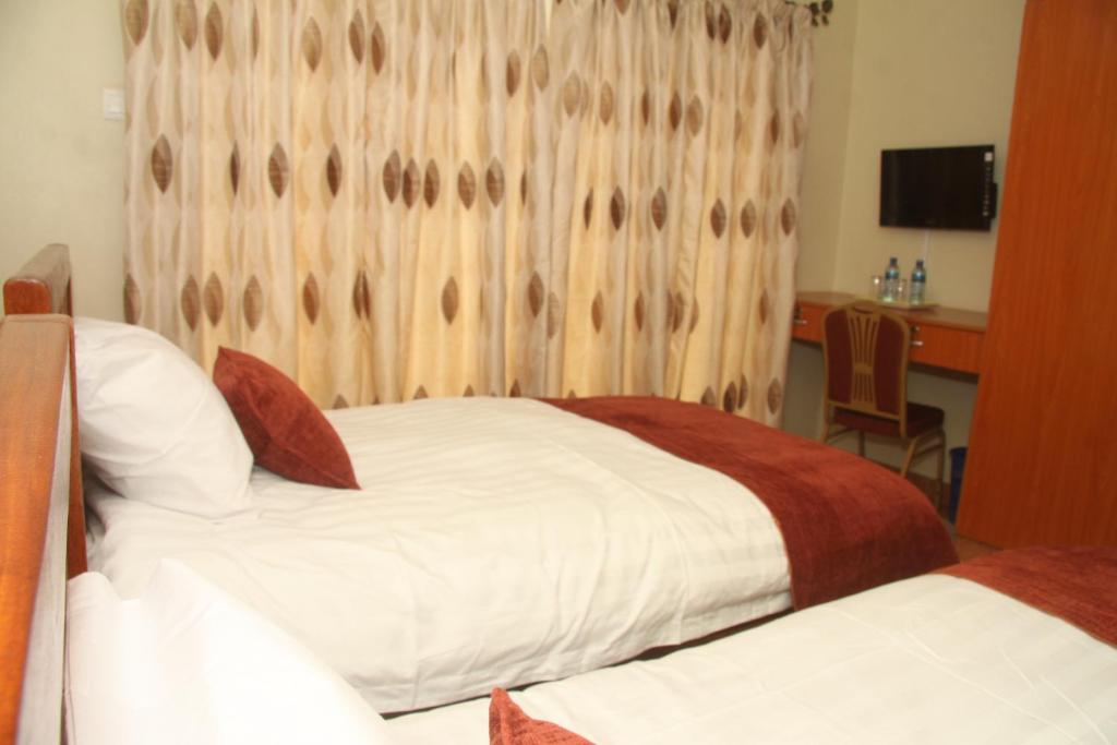 Postel nebo postele na pokoji v ubytování Nairobi Transit Hotel
