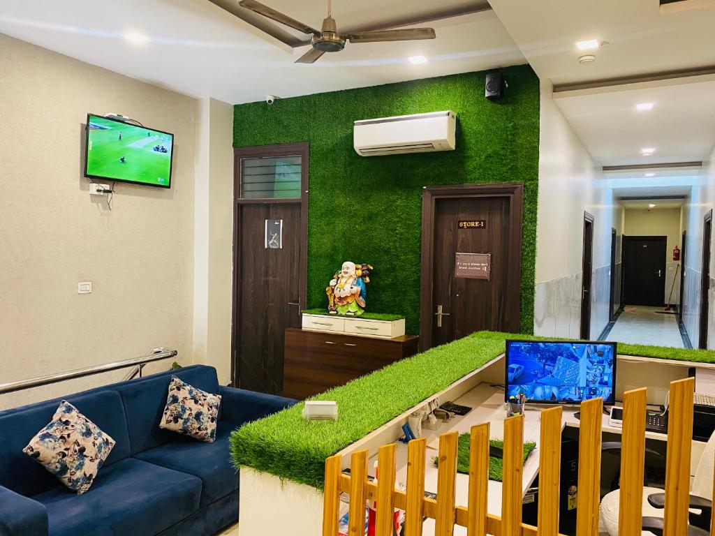 a living room with a blue couch and a green wall at The highland hotel in Bathinda