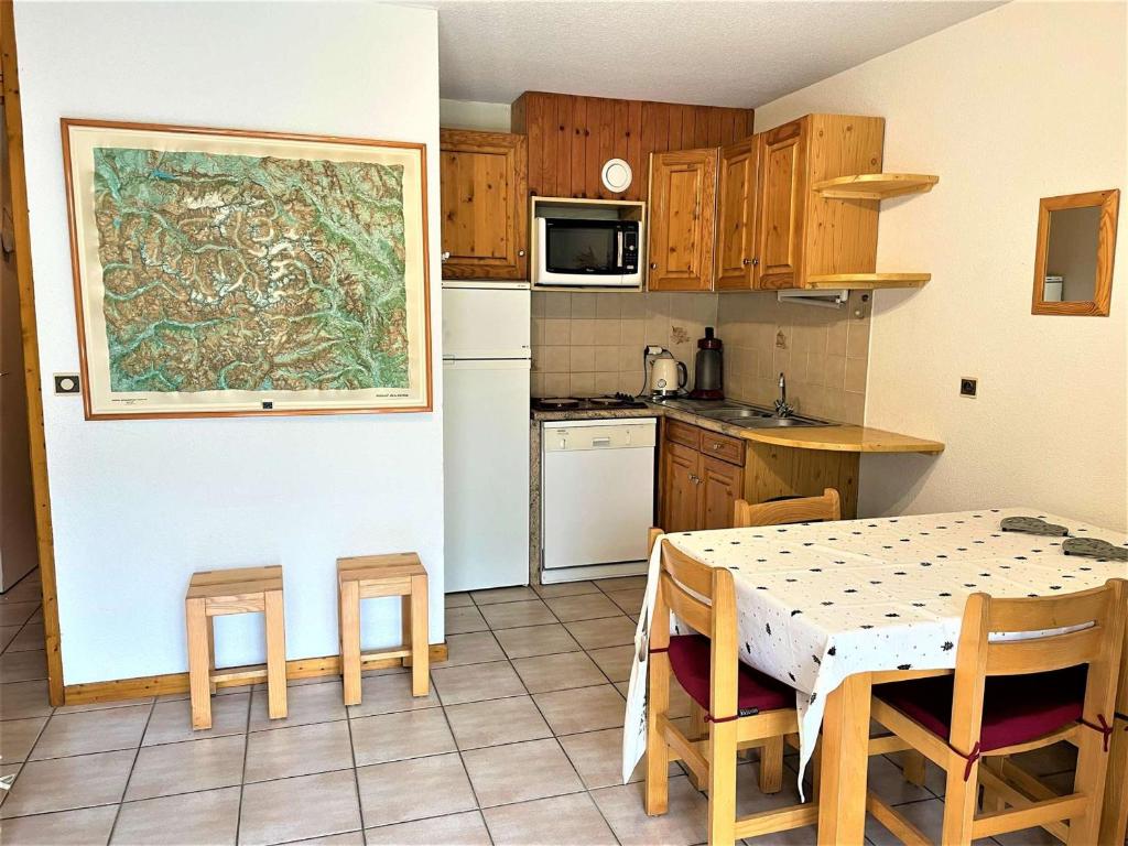 a kitchen with a table and chairs and a kitchen with a table and a table at Appartement Le Monêtier-les-Bains, 2 pièces, 4 personnes - FR-1-330F-225 in Le Reposoir