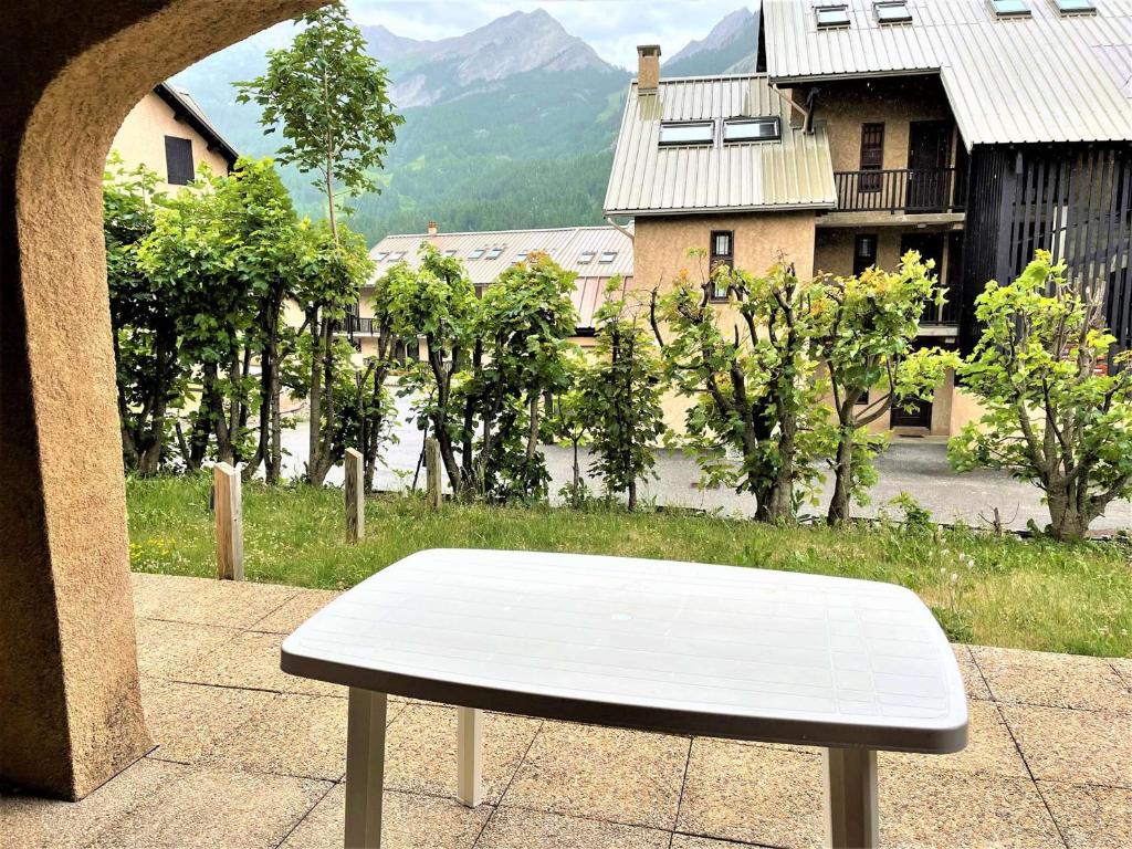 a white bench sitting on top of a sidewalk at Appartement Le Monêtier-les-Bains, 2 pièces, 4 personnes - FR-1-330F-225 in Le Reposoir
