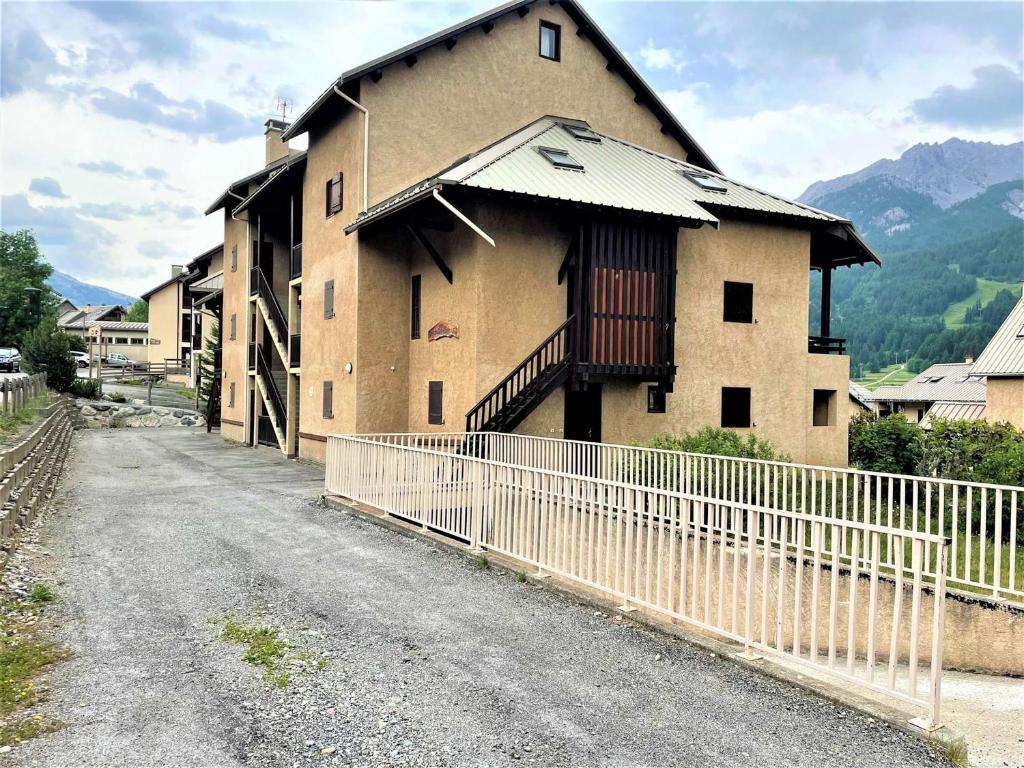 a building with a fence next to a dirt road at Appartement Le Monêtier-les-Bains, 2 pièces, 4 personnes - FR-1-330F-225 in Le Reposoir