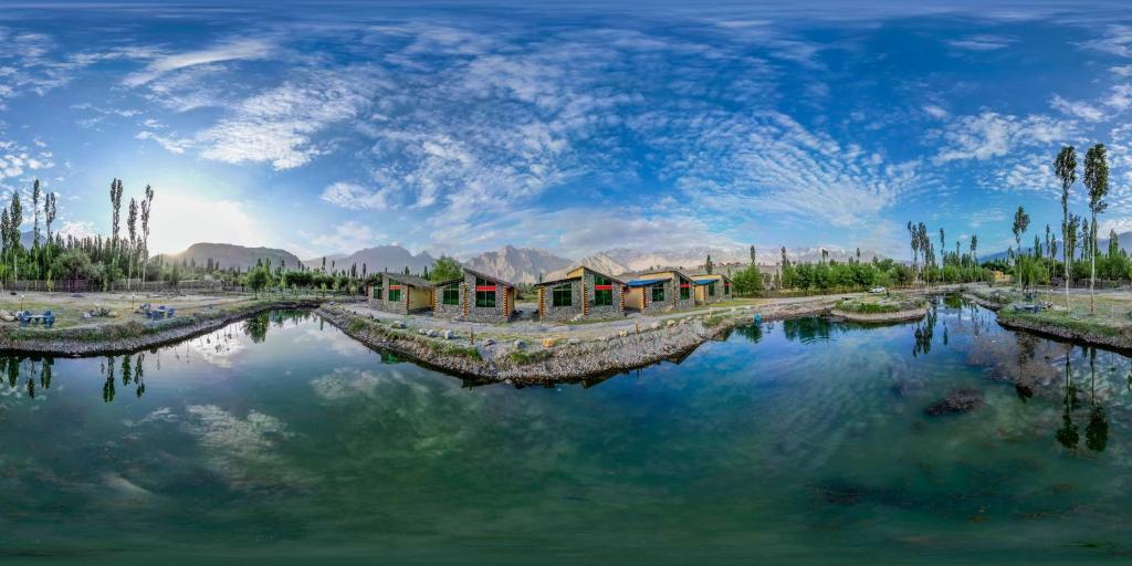 ein großer Wasserkörper mit Häusern und Bäumen in der Unterkunft LOKAL Rooms x Skardu (Katpana Retreat) in Skardu