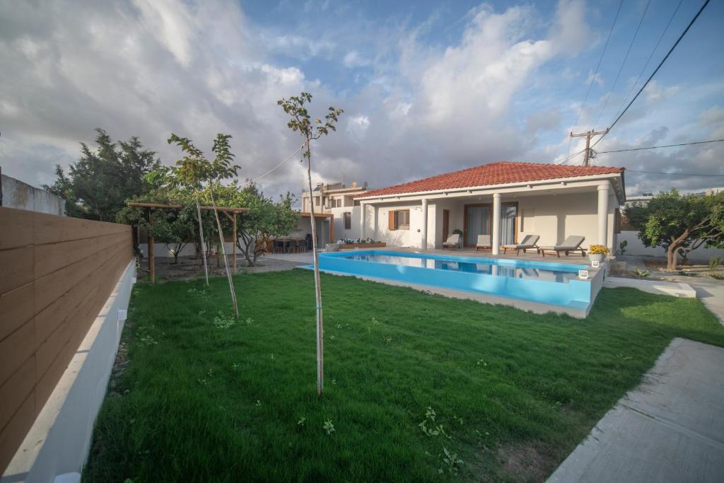 a house with a yard with a swimming pool at Avli Guest House in Tympáki