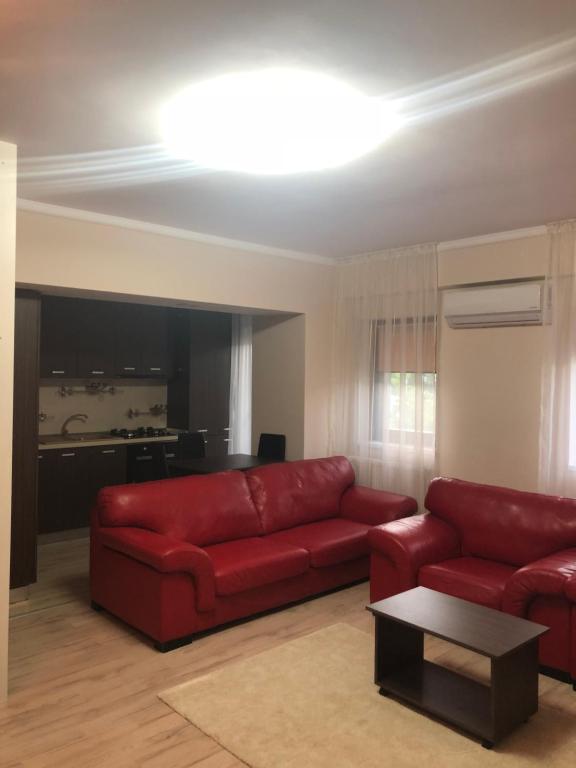 ein Wohnzimmer mit einem roten Sofa und einem Tisch in der Unterkunft Apartament cu 3 camere Rovine in Craiova