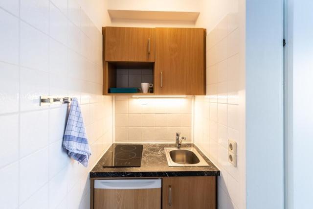 a small kitchen with a sink and a stove at Hotel ISG Heidelberg in Heidelberg