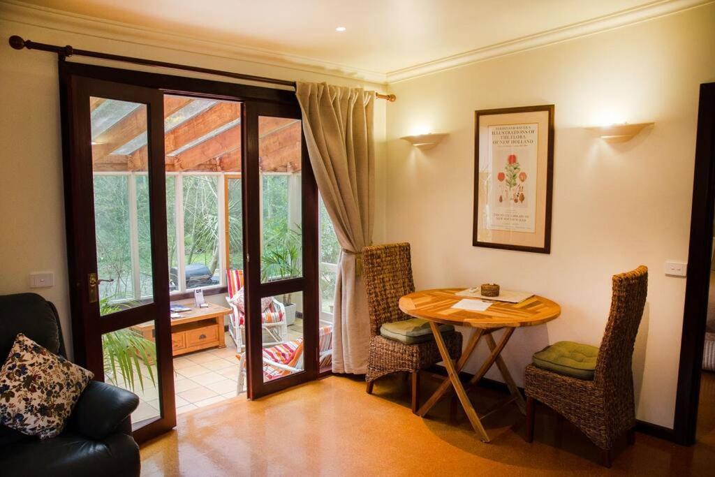a room with a table and chairs and a patio at Ashwood Cottages in Bright