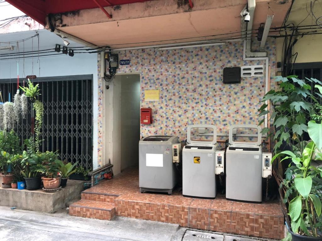 een groep van drie ouderwetse machines die buiten een gebouw zitten bij AB HOSTEL in Makkasan