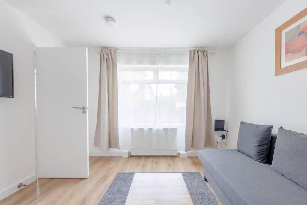 un soggiorno con divano e finestra di 2BD Apt East London Sleeps 7! a Londra