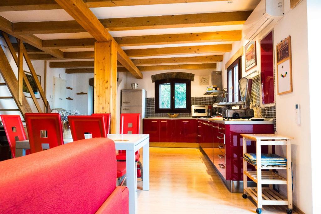 a kitchen with red chairs and a white table at Marylin & Elvis in Muggia