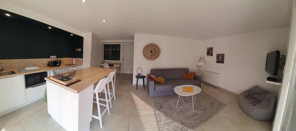 cocina y sala de estar con sofá y mesa en L'appart de Fanny en Limonest