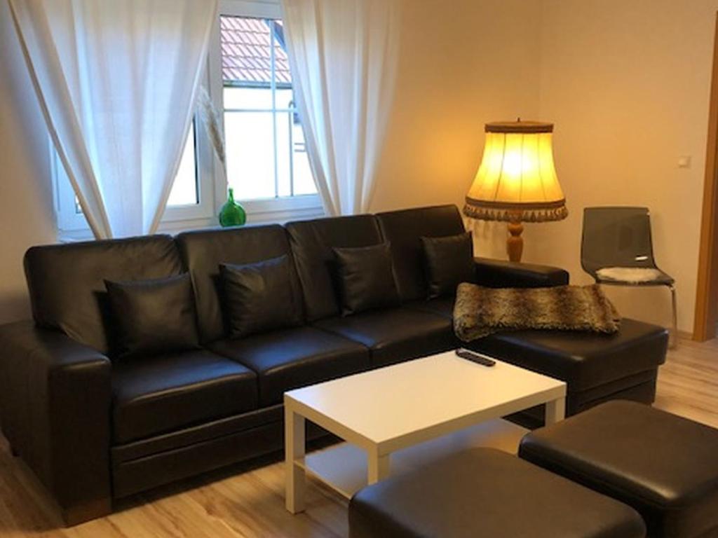 a living room with a black couch and a table at Ferienwohnung Weinberg in Markt Einersheim